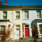 Colonial-style brick houses in Toronto with rustic charm, featuring distinct red and white doors.